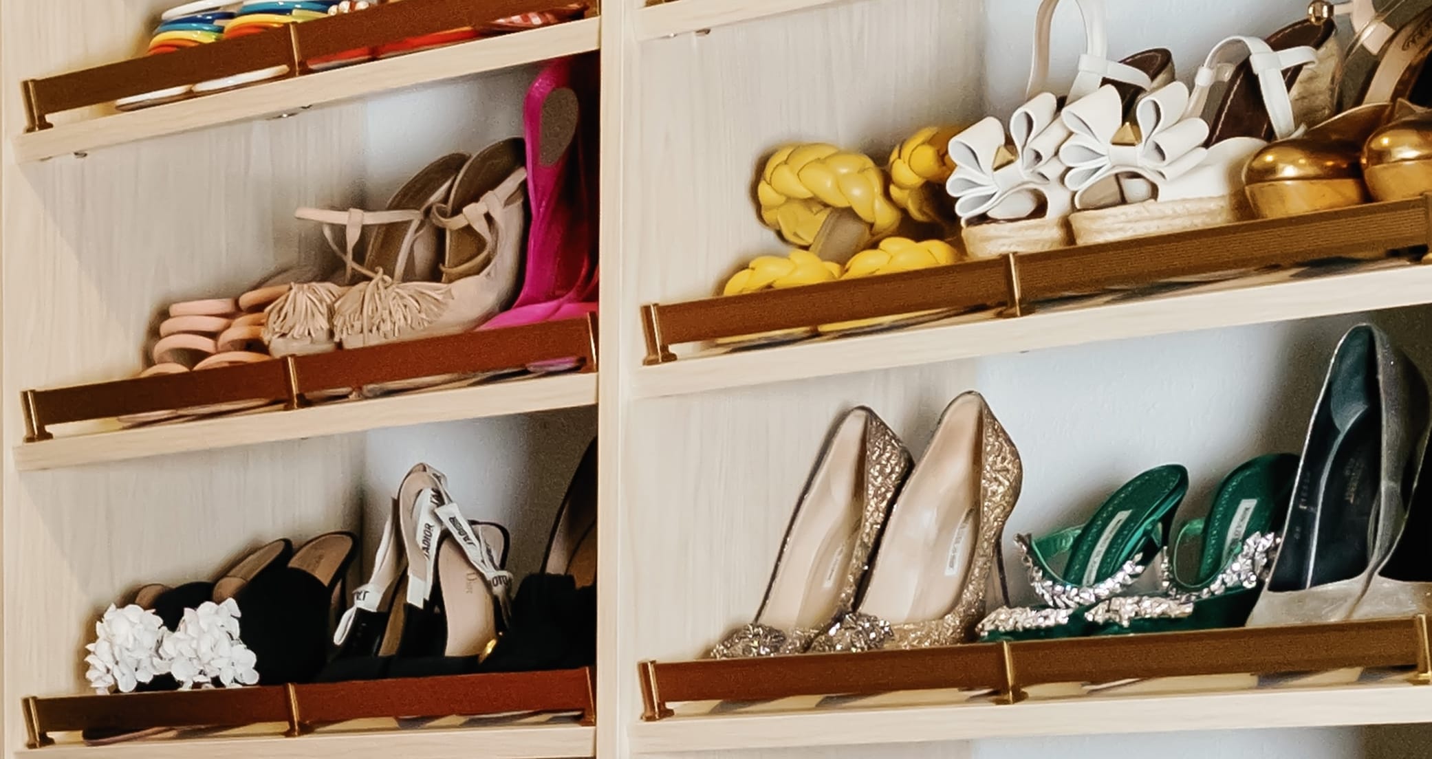 Shoe storage tilted for better visibility in a wood grain finish with toe rails by California Closets