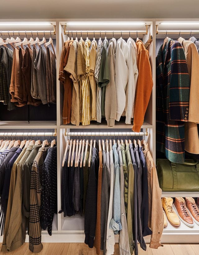 Bobby Berk’s custom designed organized walk in cloffice with hanging clothing and shoe storage by California Closets
