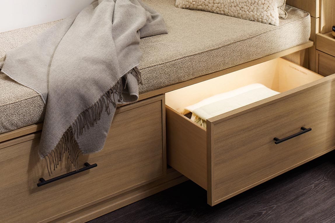 Customized bench seating with custom LED lighting for drawer by California Closets