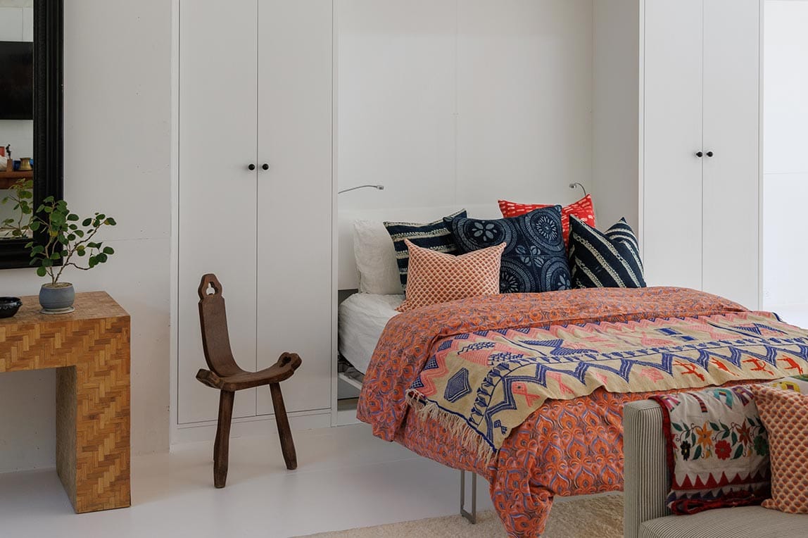 Opened murphy bed custom design in a white wood finish with gooseneck reading light by California Closets